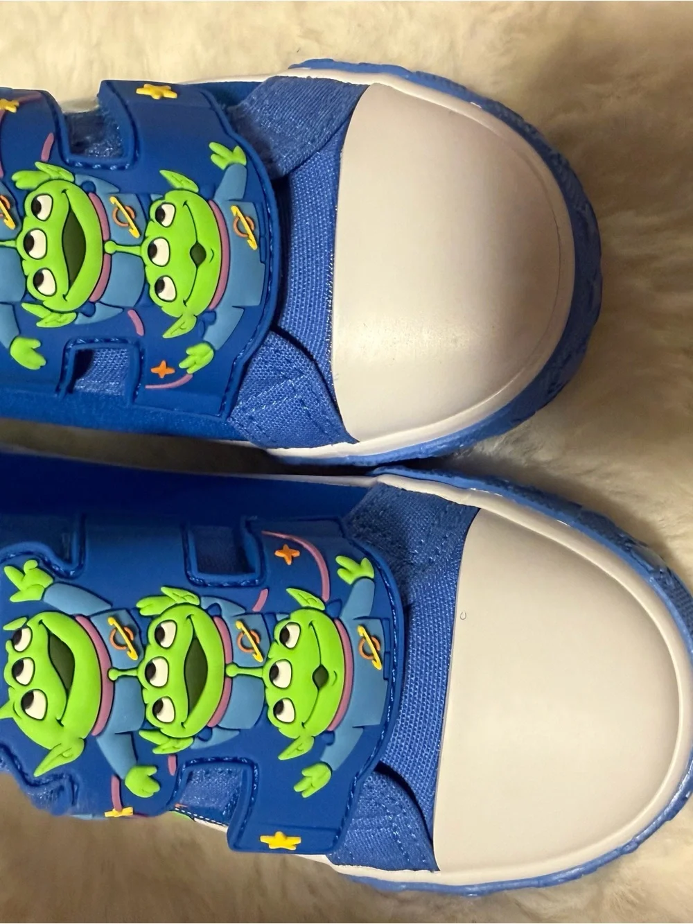 These Disney Toy Story Alien toddler shoes feature a blue canvas design with rub